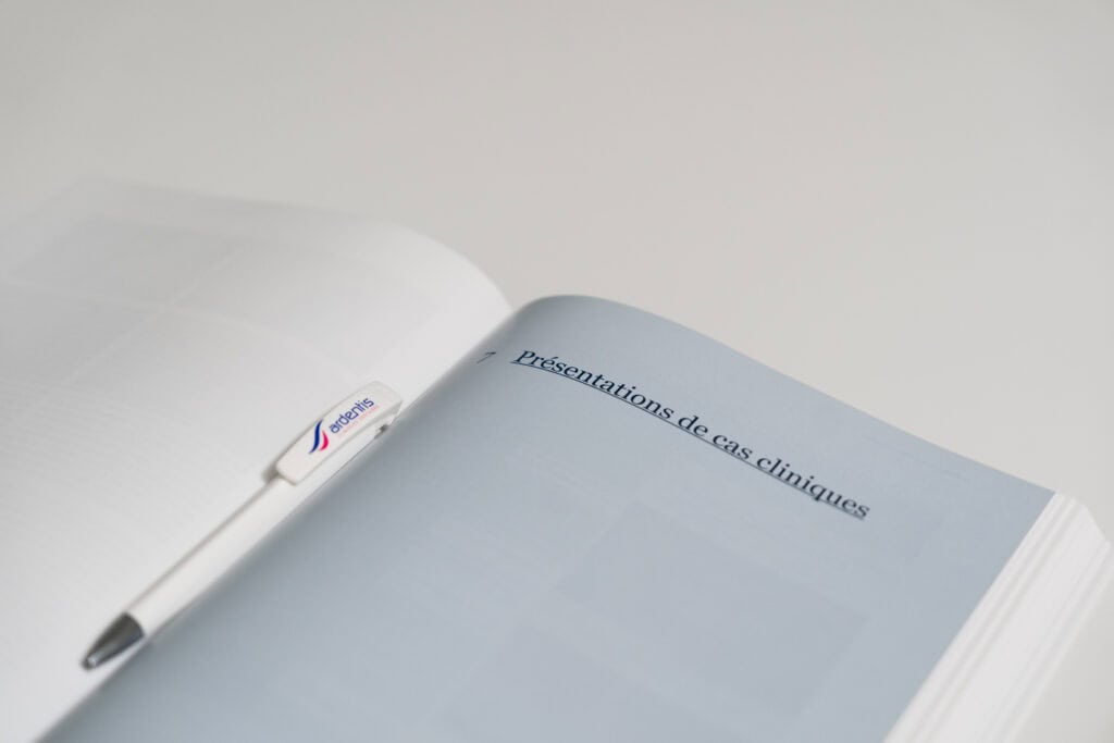 Ardentis presentation booklet open to "Presentations de cas cliniques" page, accompanied by a silver pen, on a clean white background.