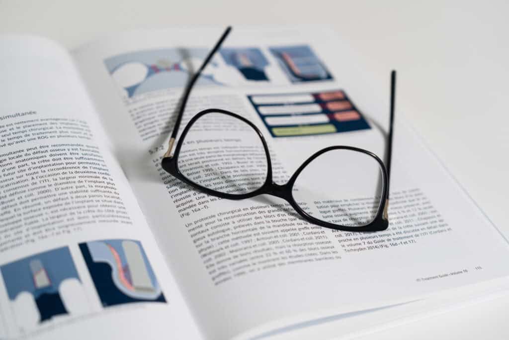 Livre médical ouvert avec illustrations dentaires et lunettes