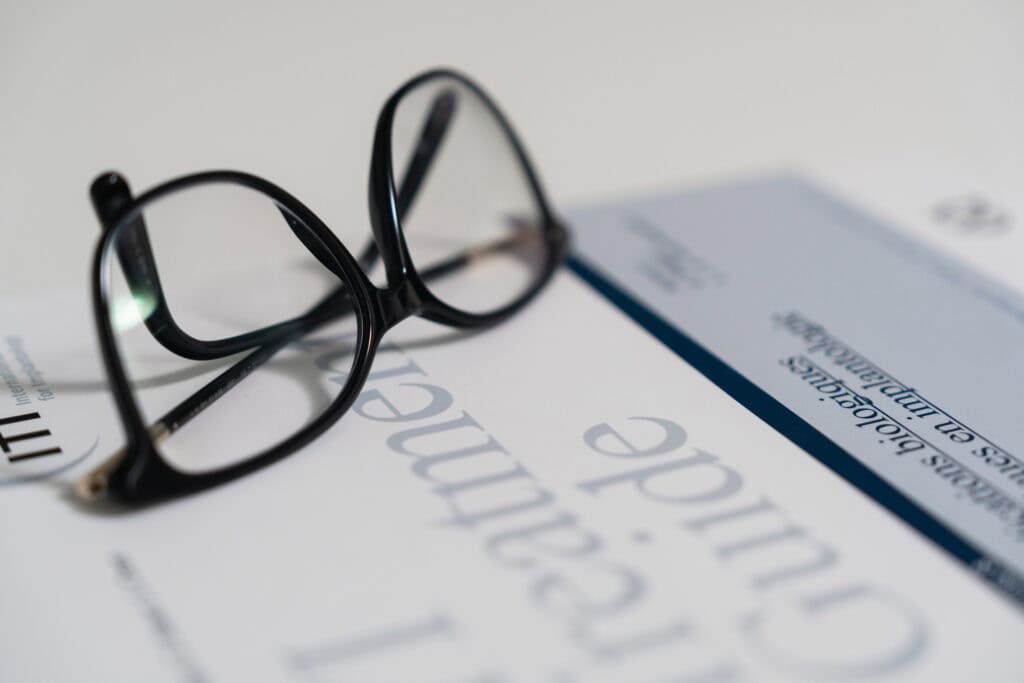 Lunettes posées sur un guide de traitement en implantologie