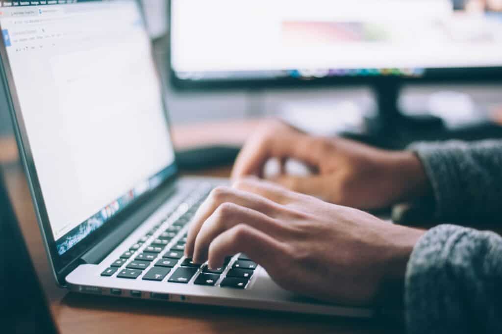 Close-up of a person typing on a laptop, representing digital dental technology and patient care at Ardentis dental clinic.