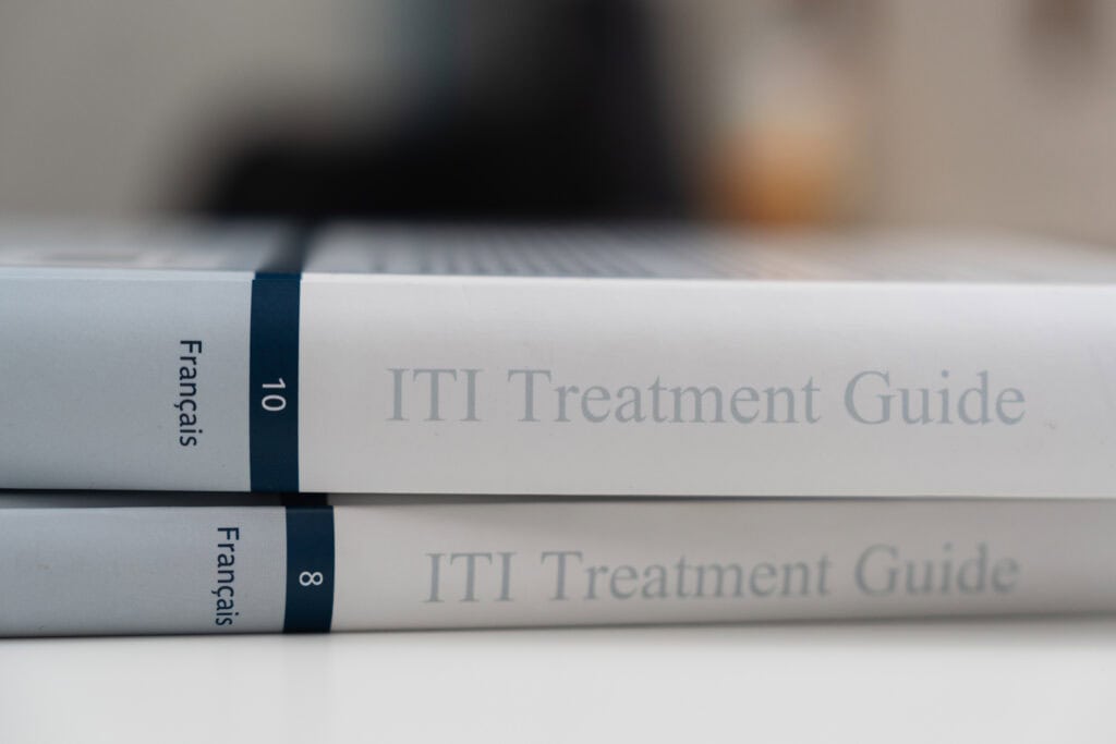Deux volumes du guide ITI Treatment Guide empilés