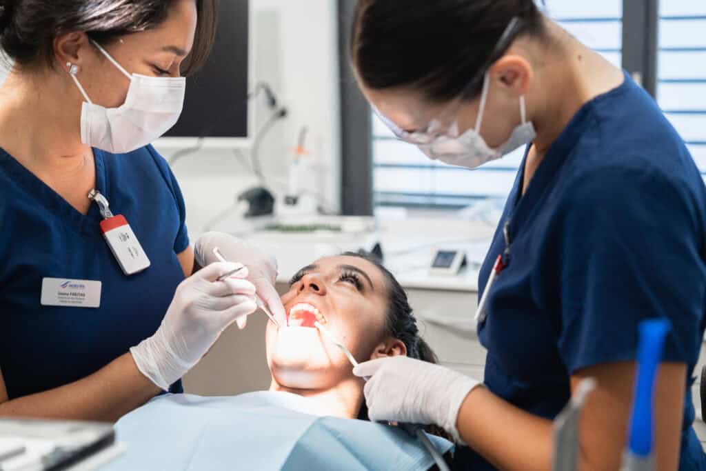 Dentistes prenant en charge une patiente en salle de soins après une intervention buccale