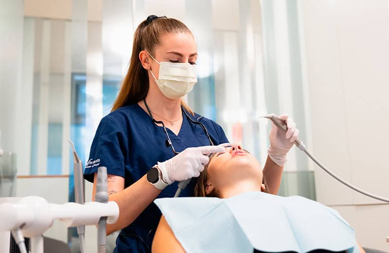 Hygiéniste dentaire réalisant un détartrage sur une patiente