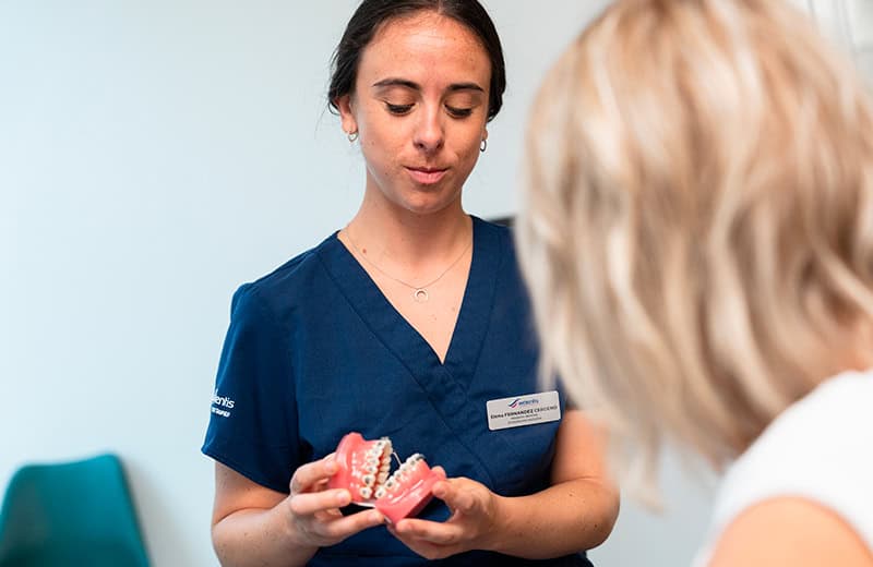 Orthodontiste expliquant un traitement avec un modèle dentaire
